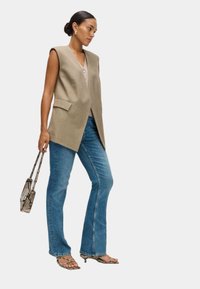 Длинный жилет