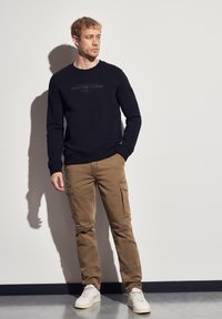 Брюки с накладными карманами Брюки с накладными карманами