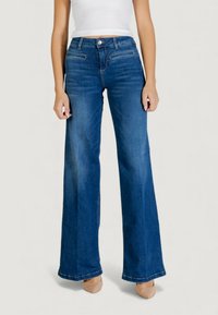 Клешеные джинсы