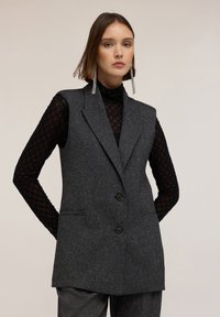 Длинный жилет