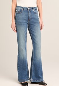 Клешеные джинсы